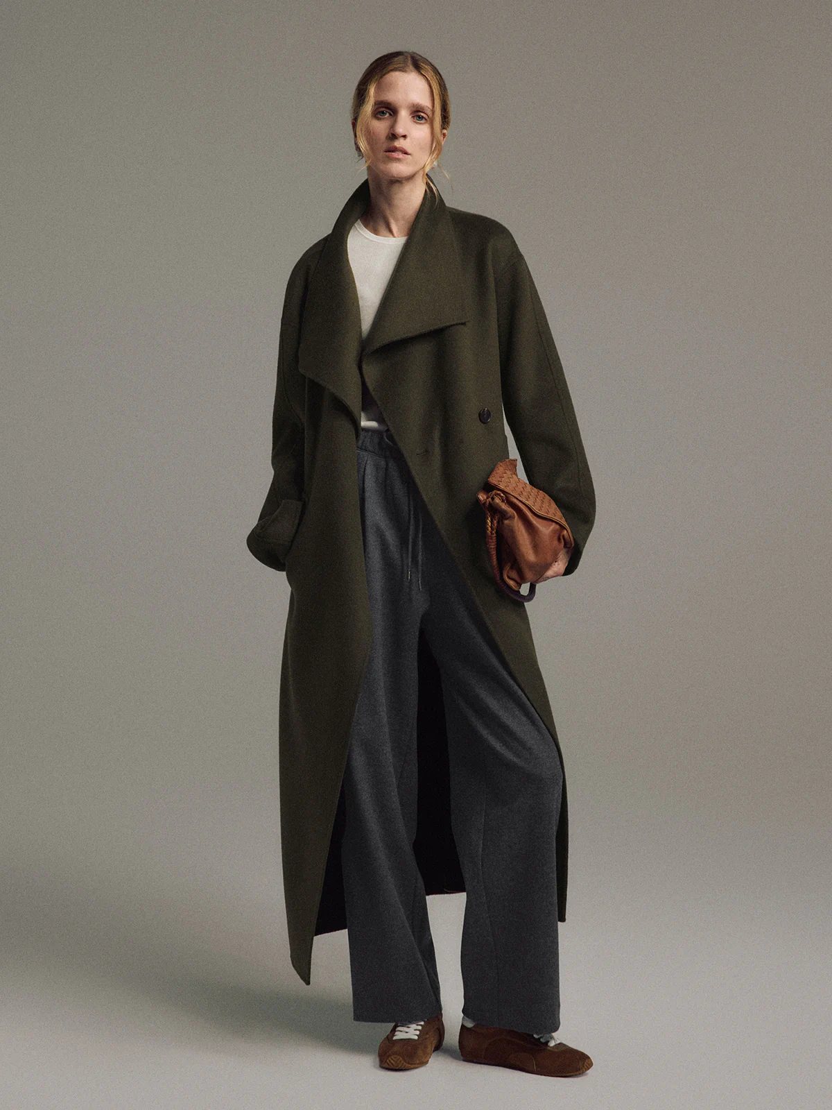 Front view of a model wearing the Olive TANSY long coat with wide lapels, front pockets, and double-face construction.
