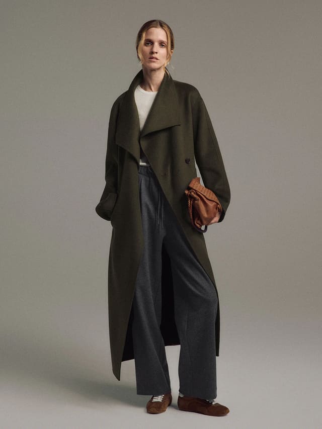 Front view of a model wearing the Olive TANSY long coat with wide lapels, front pockets, and double-face construction.