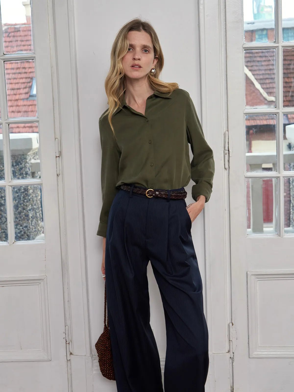 Andreatang ERIN Classic Lyocell Shirt in olive green styled with navy pleated trousers and woven leather belt — quiet luxury minimalist outfit