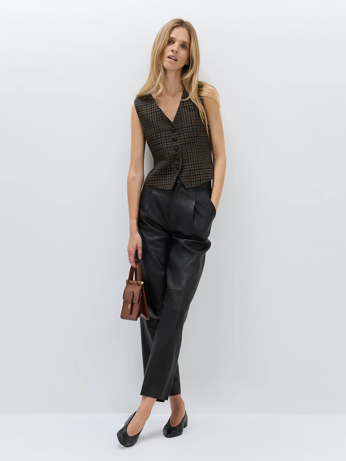 andreatang deep-brown vintage check vest worn as a top with black leather trousers and small brown handbag