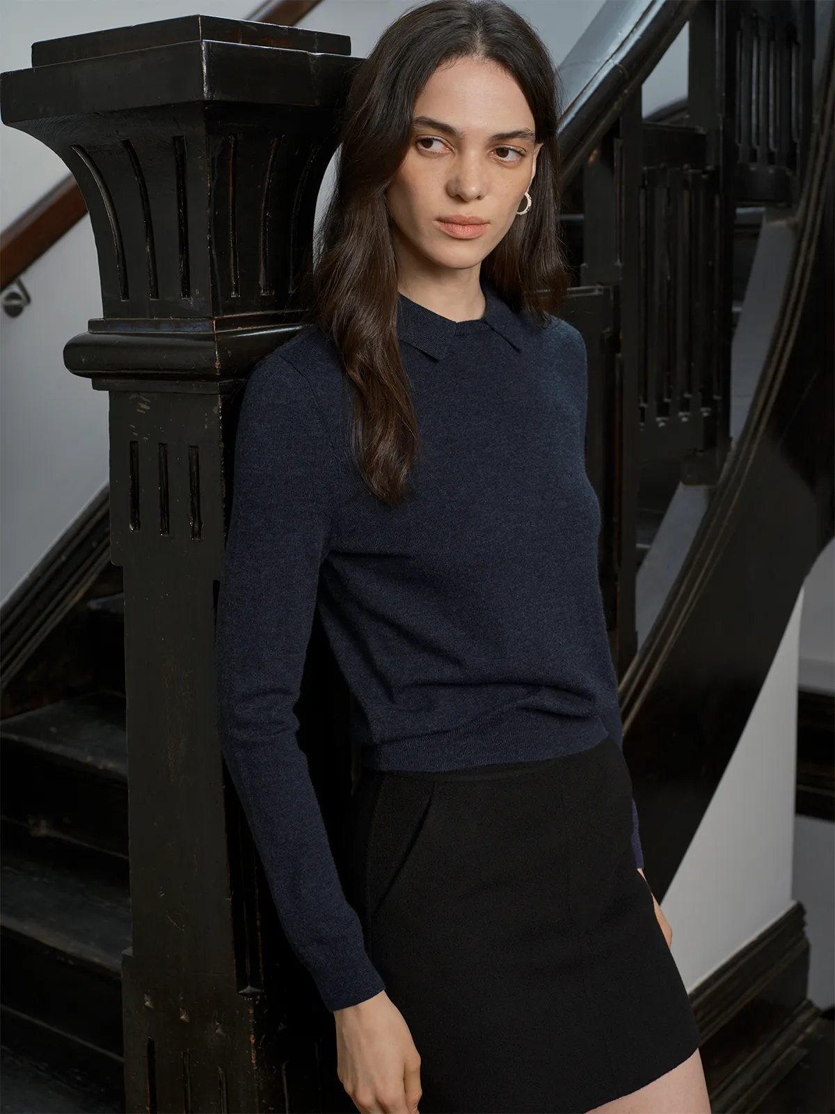 Model in navy LOUANE Layered Collar Jumper leaning against black wooden staircase baluster