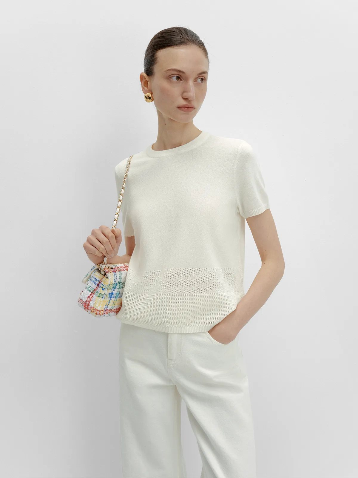 andreatang LIANA white knit t-shirt with hollow-hem panel, styled with cream trousers and multicolor tweed bag, quiet luxury minimalism