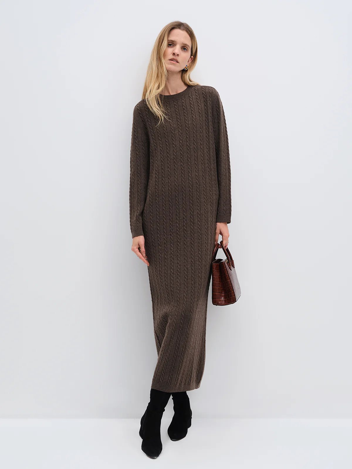 Model wearing andreatang cream Merino cable-knit maxi dress over a charcoal turtleneck with black boots