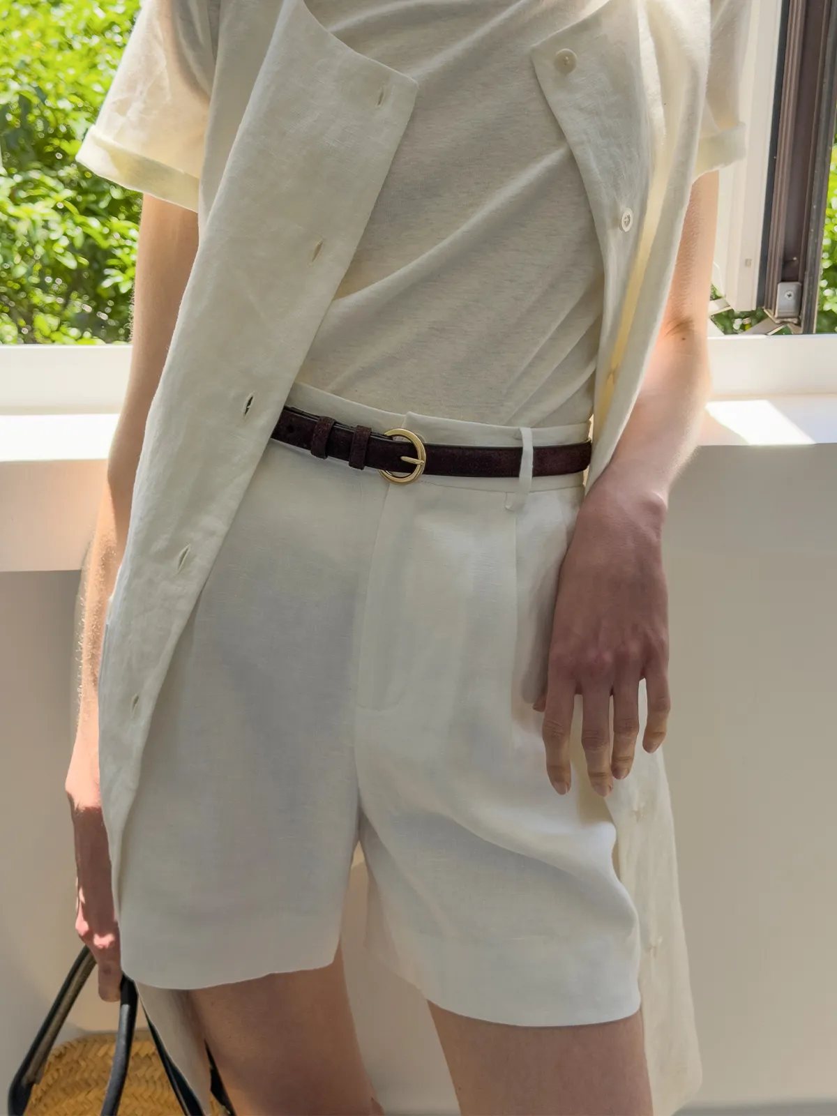 RANGER belt styled with ivory linen shorts and draped vest, natural light balcony setting