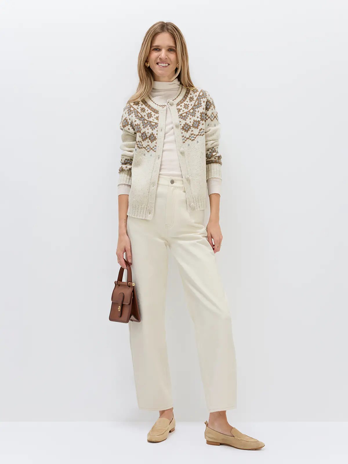 Front view of model wearing white denim-look curved-leg trousers with a belt and sweater.
