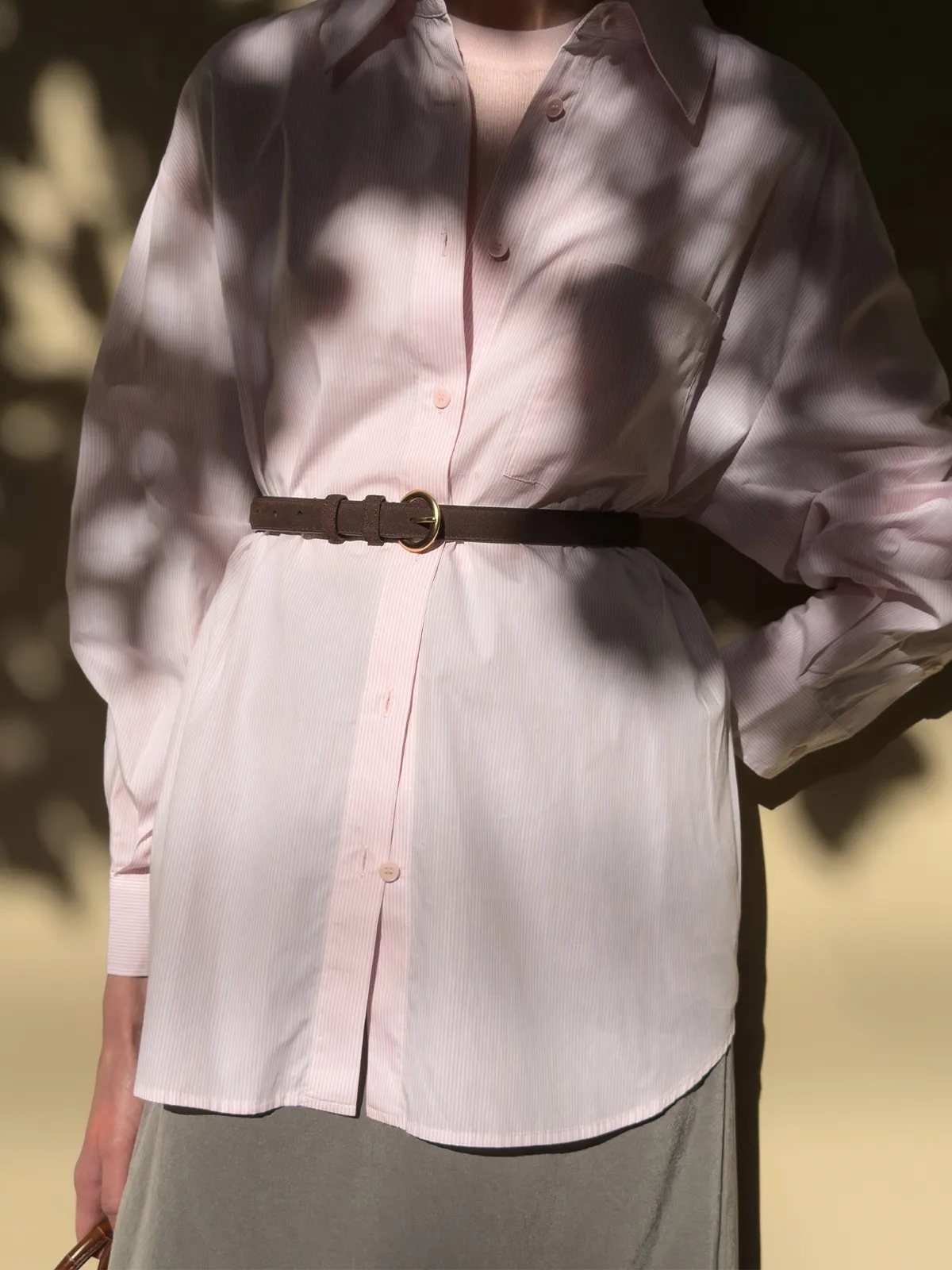 RANGER suede belt worn with oversized pink striped shirt and grey skirt, dappled sunlight