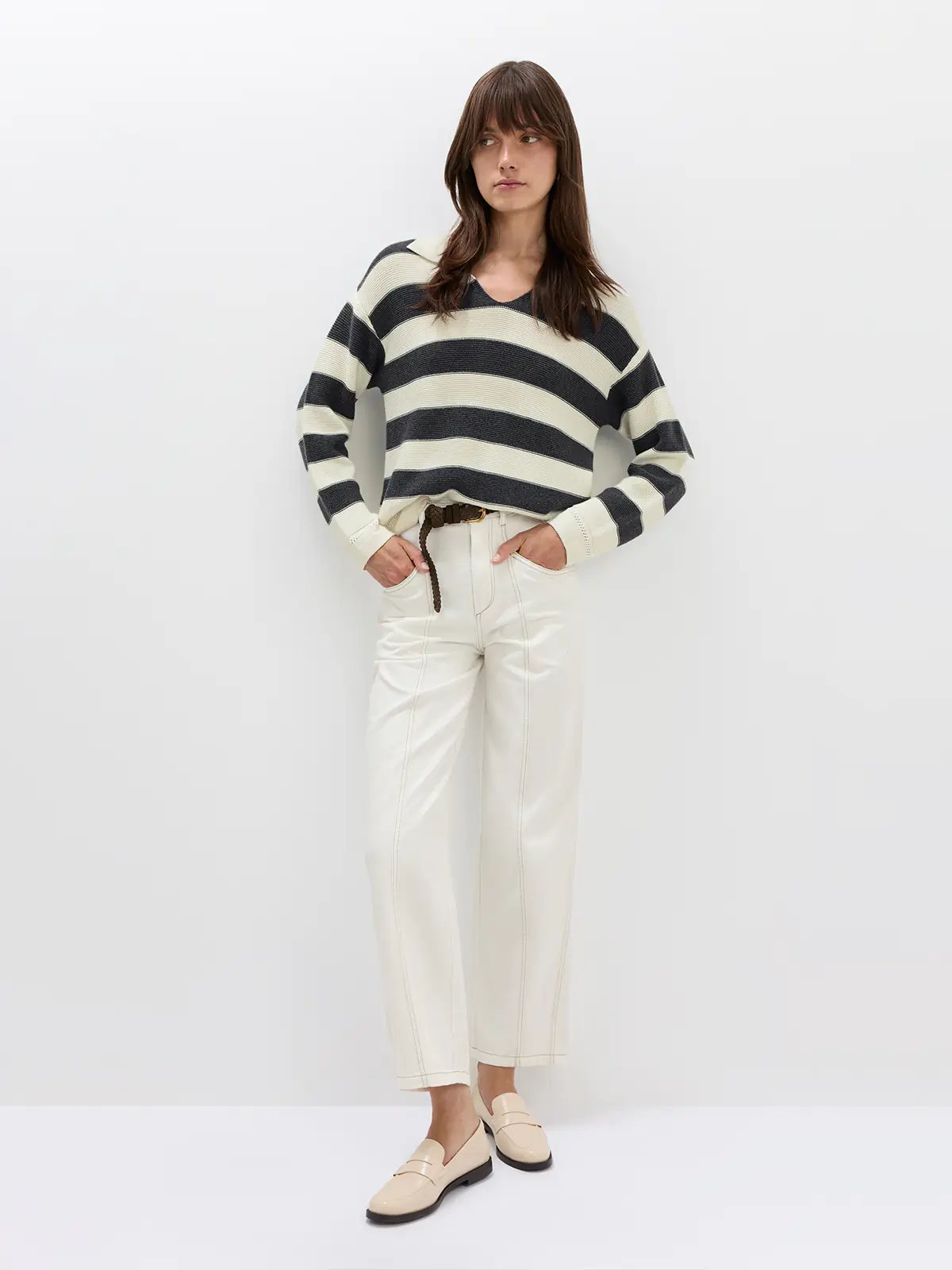 Model in a Grey/White striped V-neck jumper with arms crossed, wearing a straw hat and dark shorts.