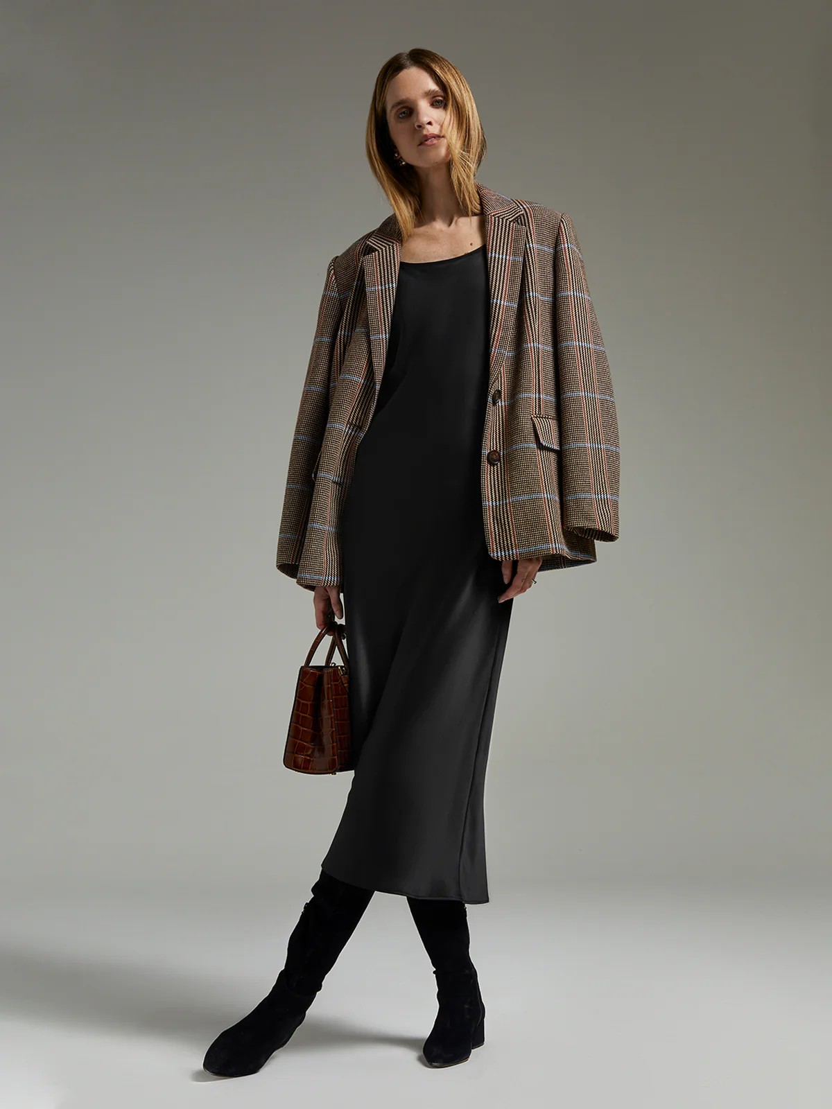 andreatang British check wool blazer layered over black slip dress with knee boots