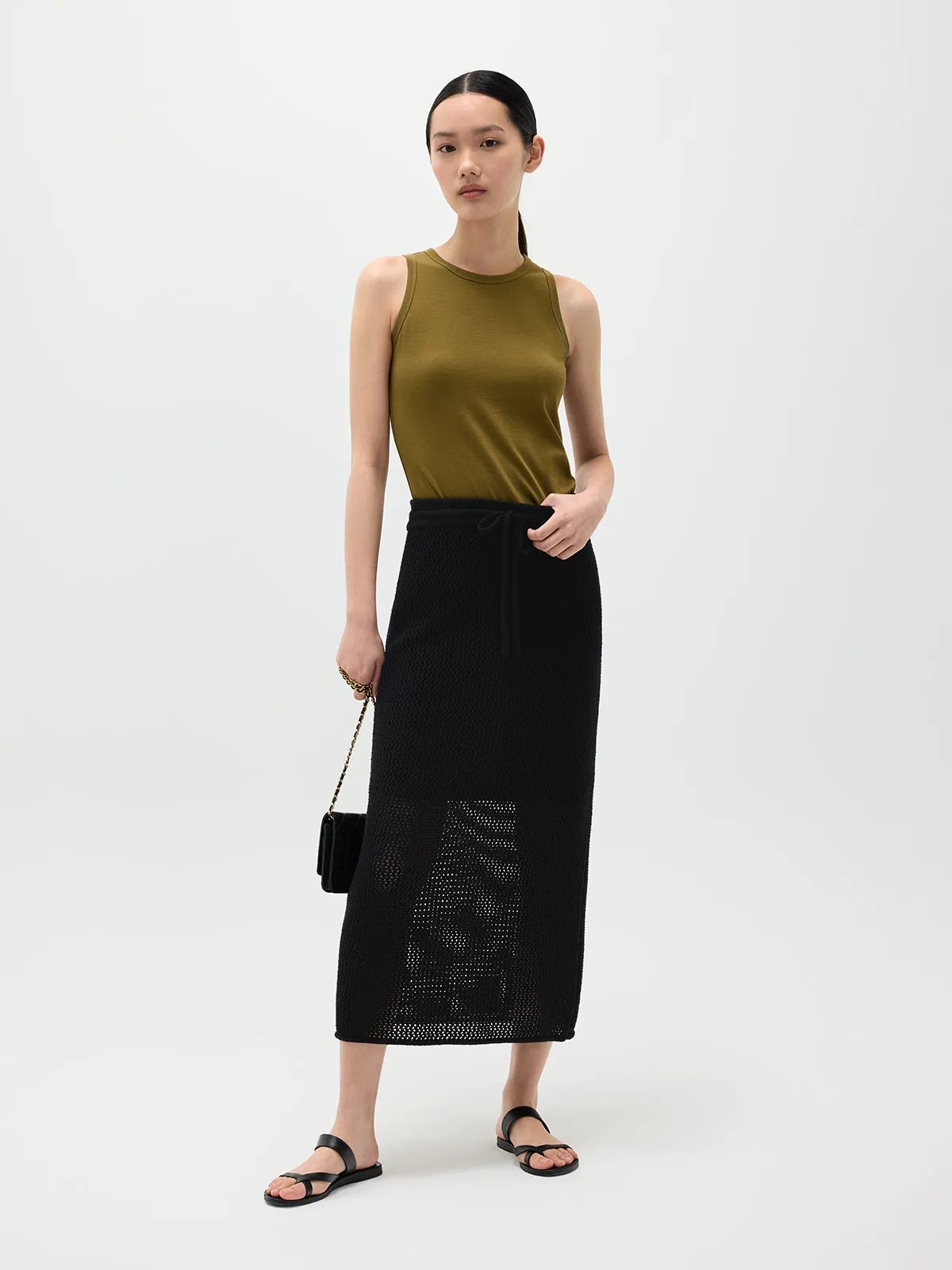 Model in olive HOLLY tank top with black open-knit maxi skirt and black sandals