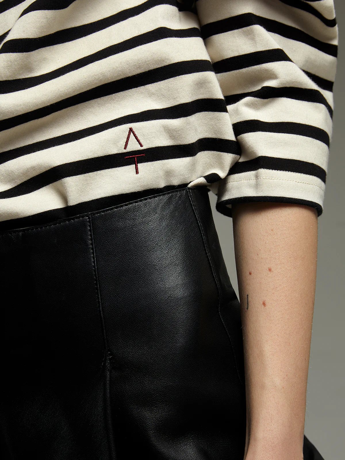 Model in a Black/White striped heavyweight cotton t-shirt with long sleeves and loose silhouette.