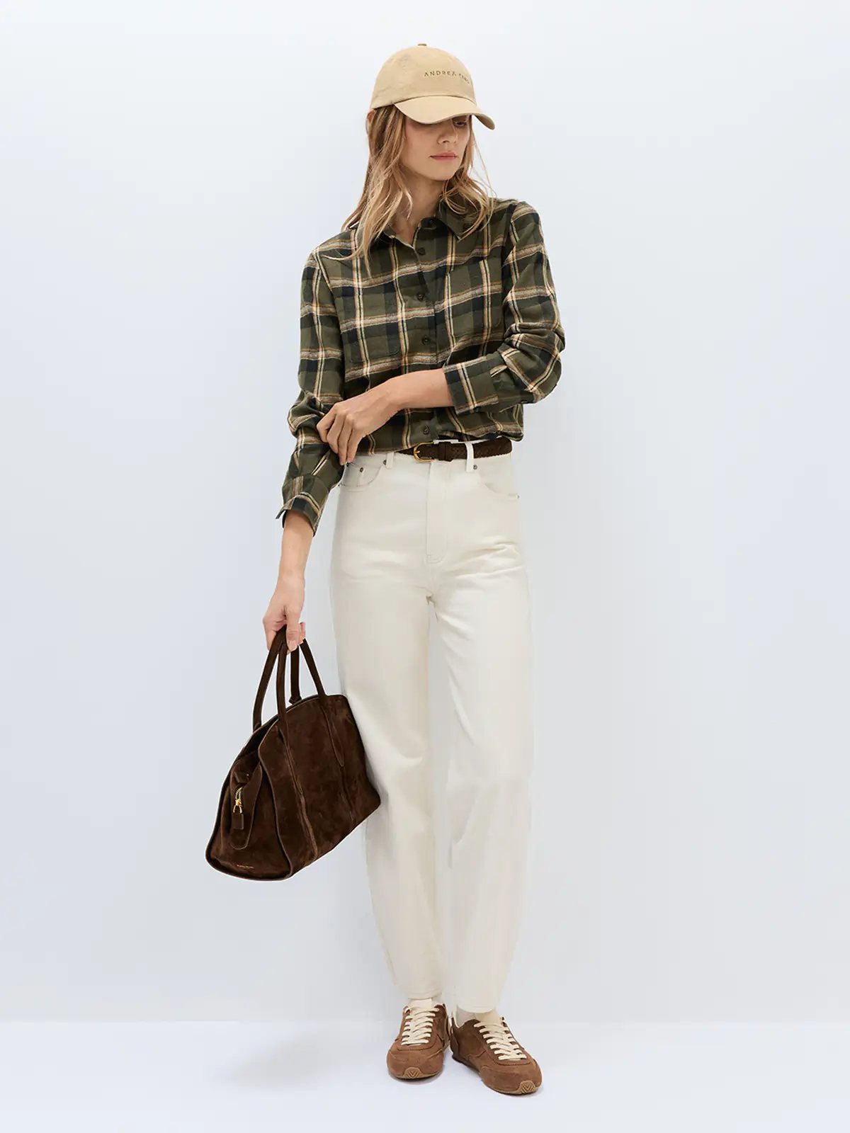 Close-up of back pocket and waistband detail on white denim-look curved-leg trousers, showing stitching and button.