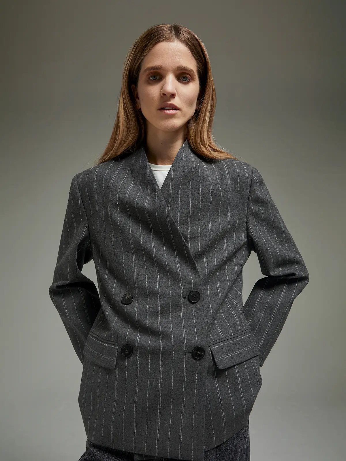 Front-facing close-up of gray double-breasted blazer with pinstripes, buttons, and notched lapels.