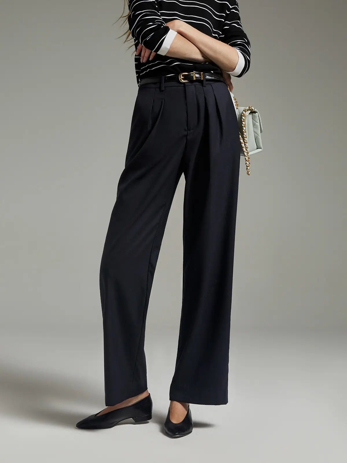 Midnight Blue classic wool wide-leg trousers with pleats, worn with striped top and belt, waist-down crop.