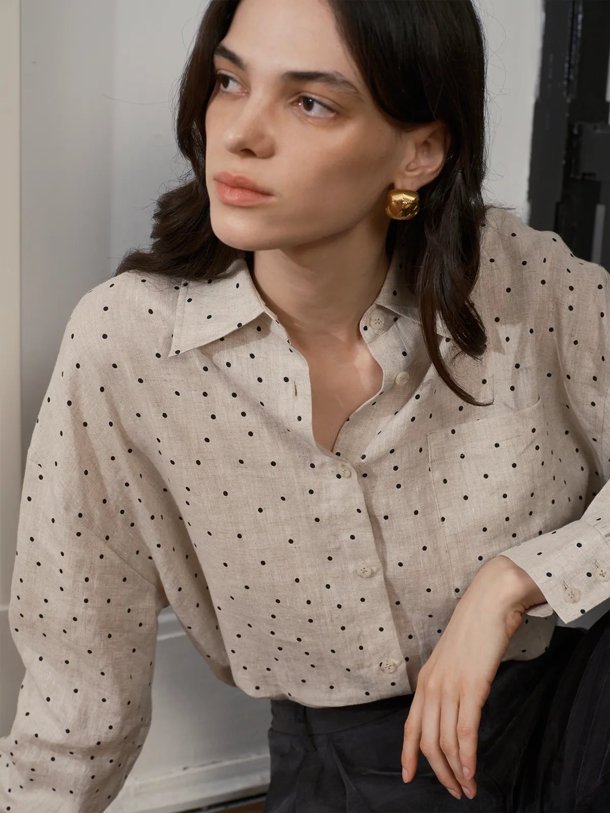 Close-up of model’s neckline, chest pocket, and gold earring pairing with ODELIA linen shirt