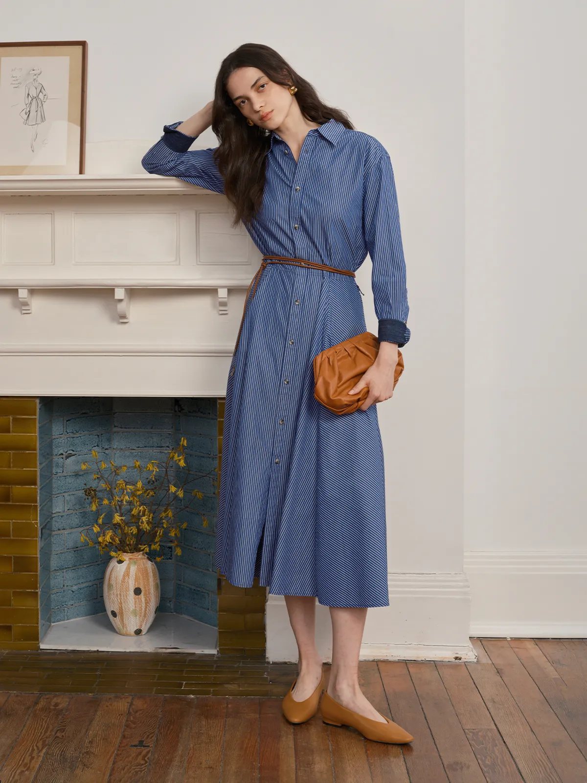 BLUE SAIL Midi dress with tan leather belt and clutch, model leaning by fireplace with vintage sketch