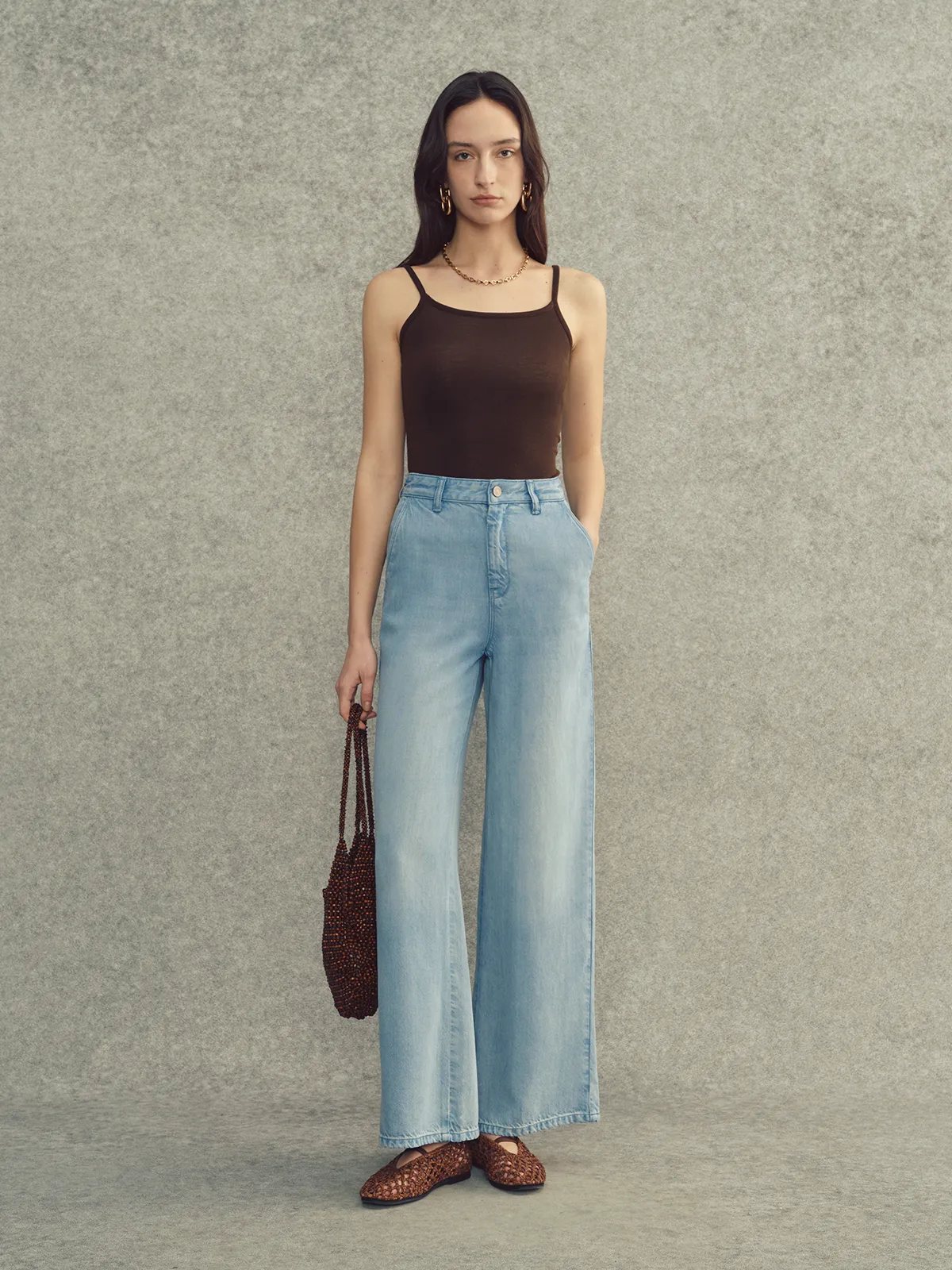 Full front view of LEANNE jeans with brown bodysuit, beaded tote, and woven flats—monochromatic earth tone styling
