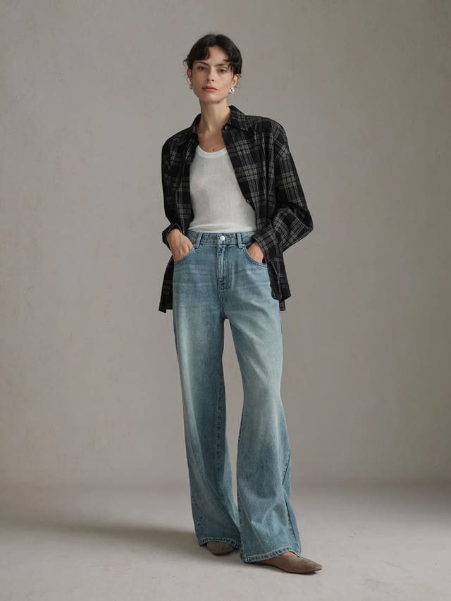 Front full-body shot of woman wearing andreatang ALDER corduroy overshirt open over white ribbed tank with wide-leg jeans