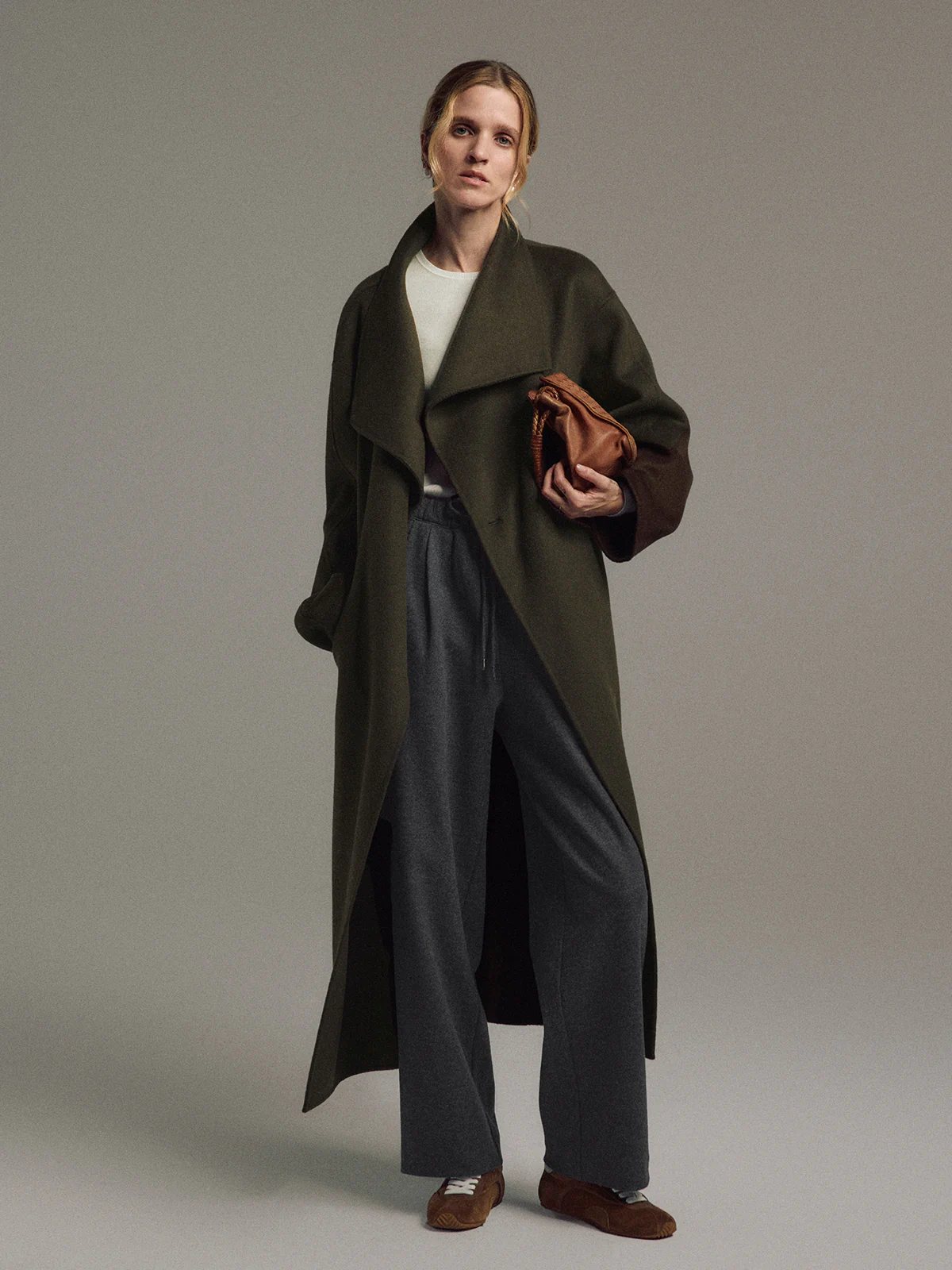 Front view of the Olive TANSY long coat with oversized silhouette, wide collar, and visible front closure over layered tops.