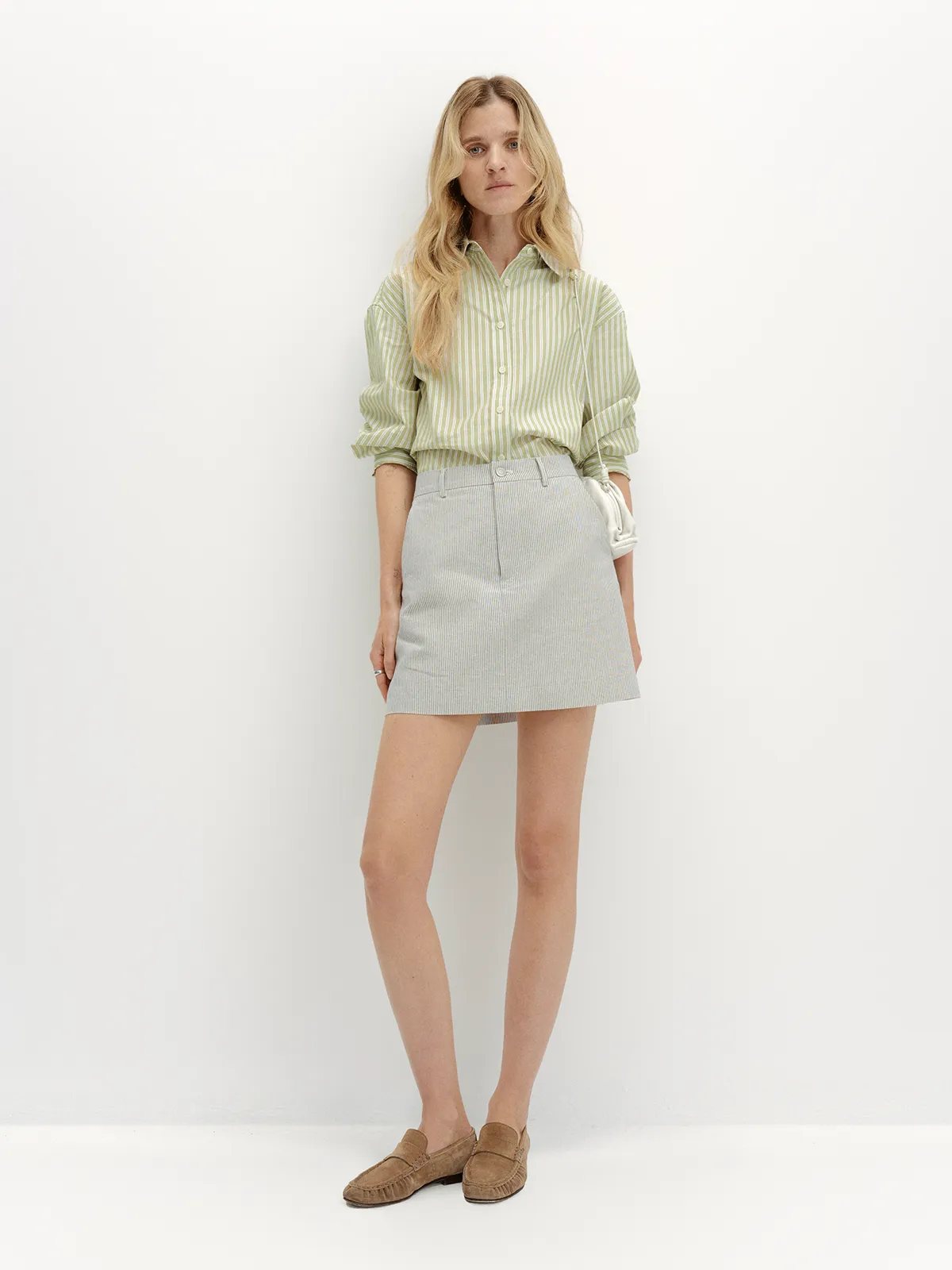 andreatang DEVON Oxford Stripe Mini Skirt styled with mint green striped shirt and brown suede loafers, front full-body view