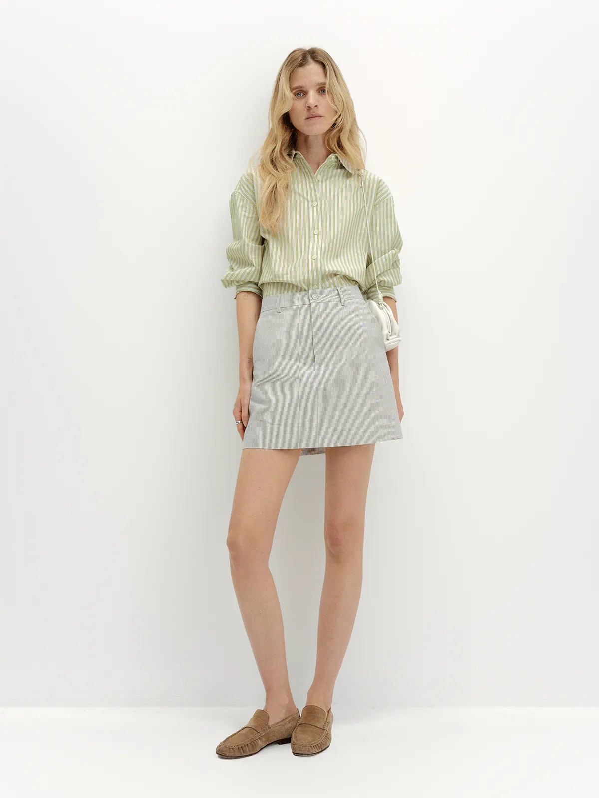 andreatang DEVON Oxford Stripe Mini Skirt styled with mint green striped shirt and brown suede loafers, front full-body view