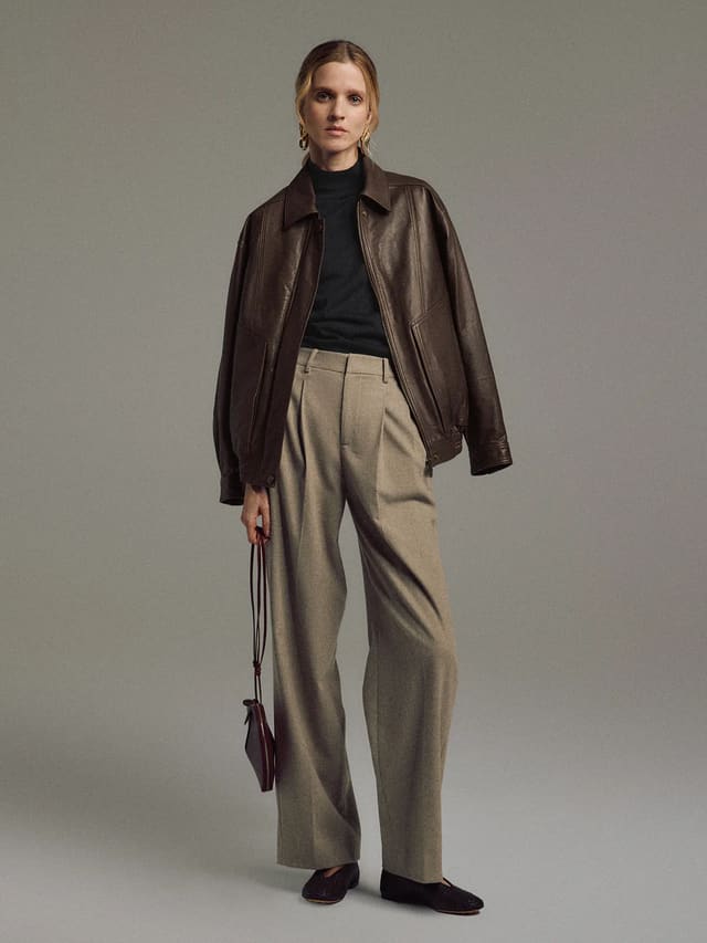 Model wearing a Dark Brown Italian shearling leather jacket with detachable lining, front view.