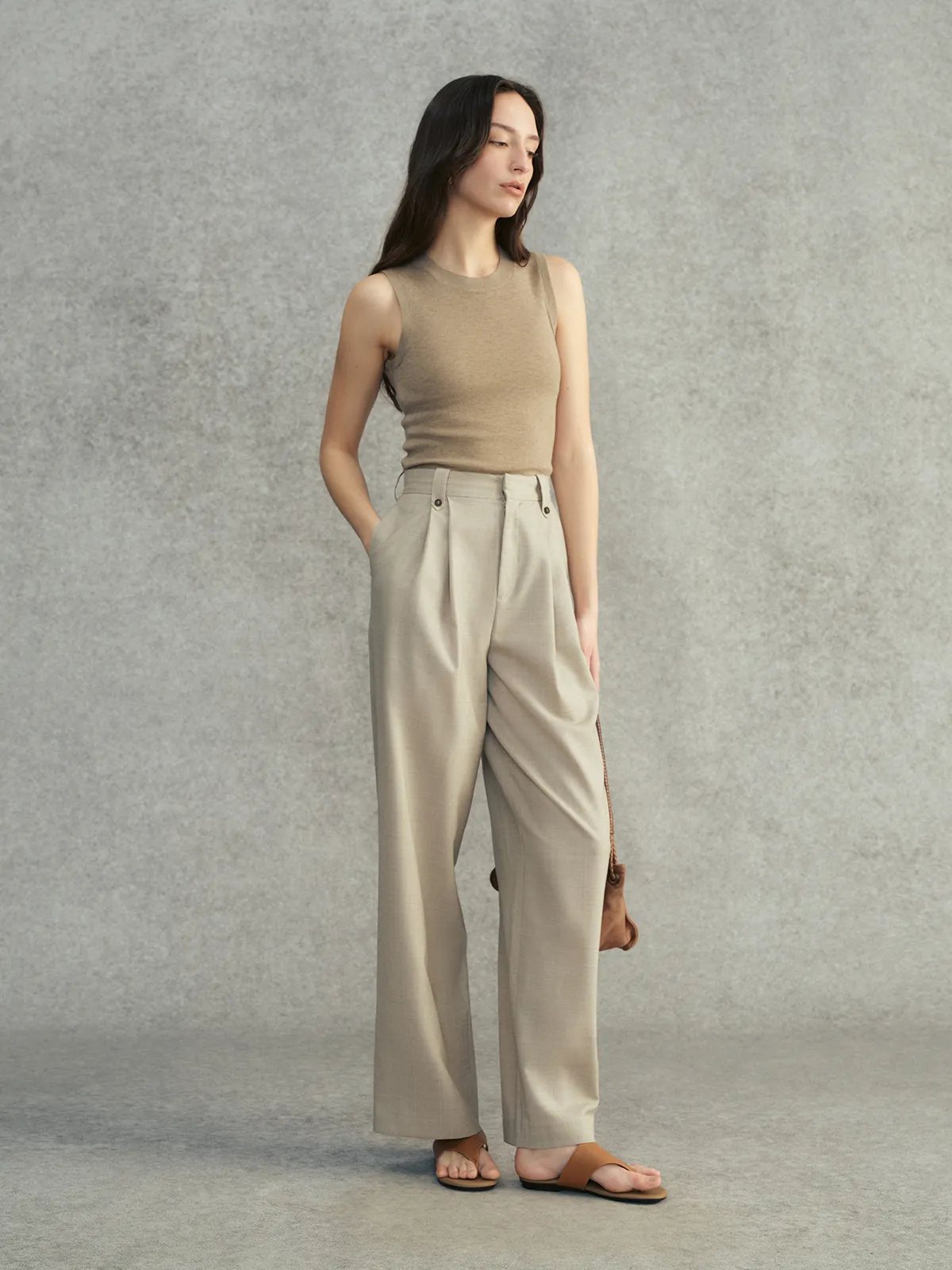 Model in warm taupe DELIA knit top with beige wide-leg trousers and tan leather sandals