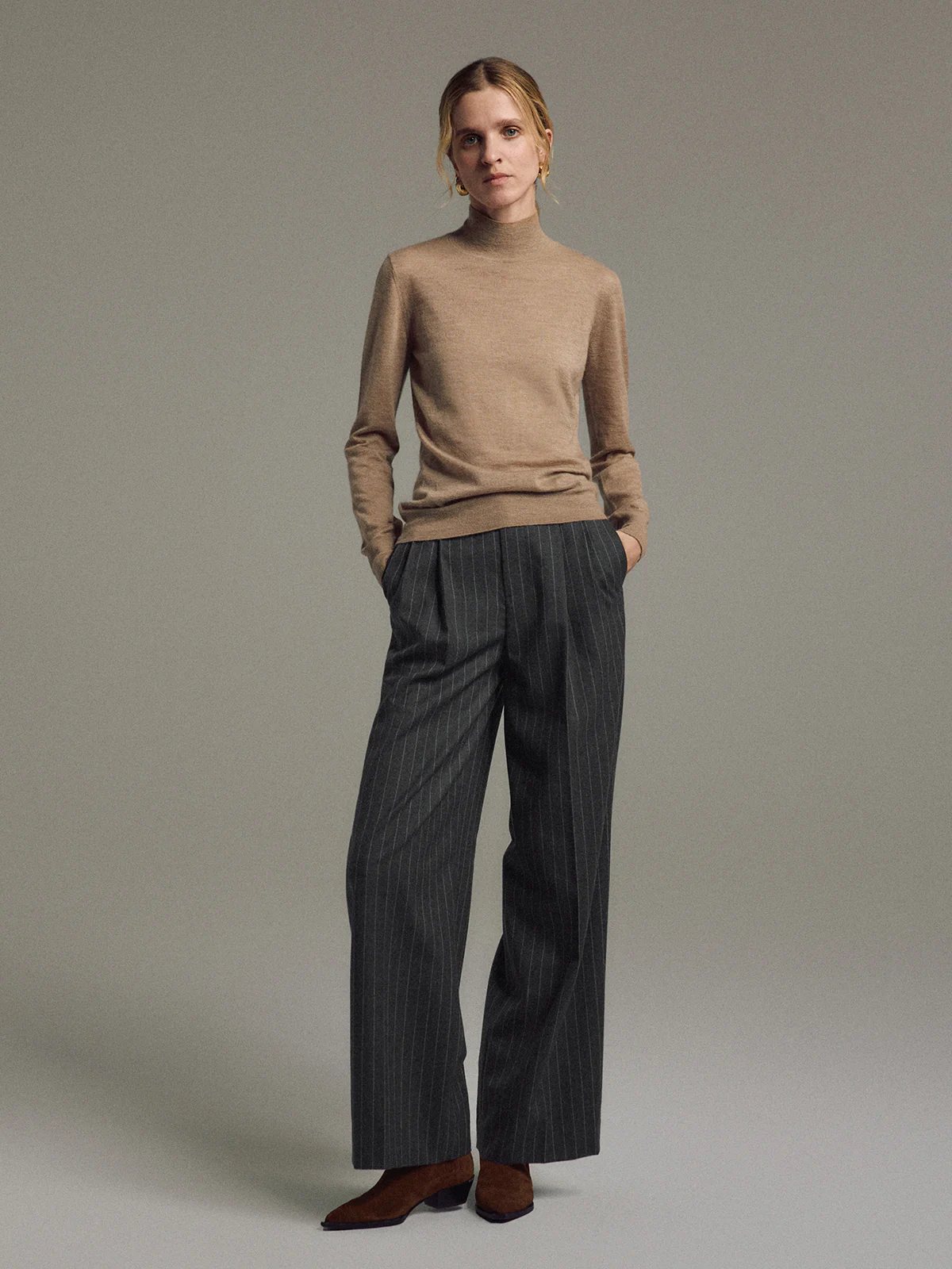 Front-facing model wearing Dark Gray wool striped wide-leg trousers with hands in pockets.