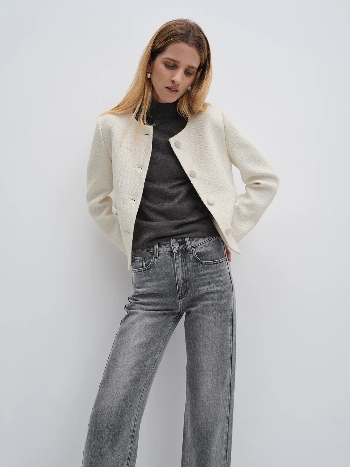 Close-up of andreatang ivory tweed cropped jacket showing round neckline, covered buttons and textured fabric