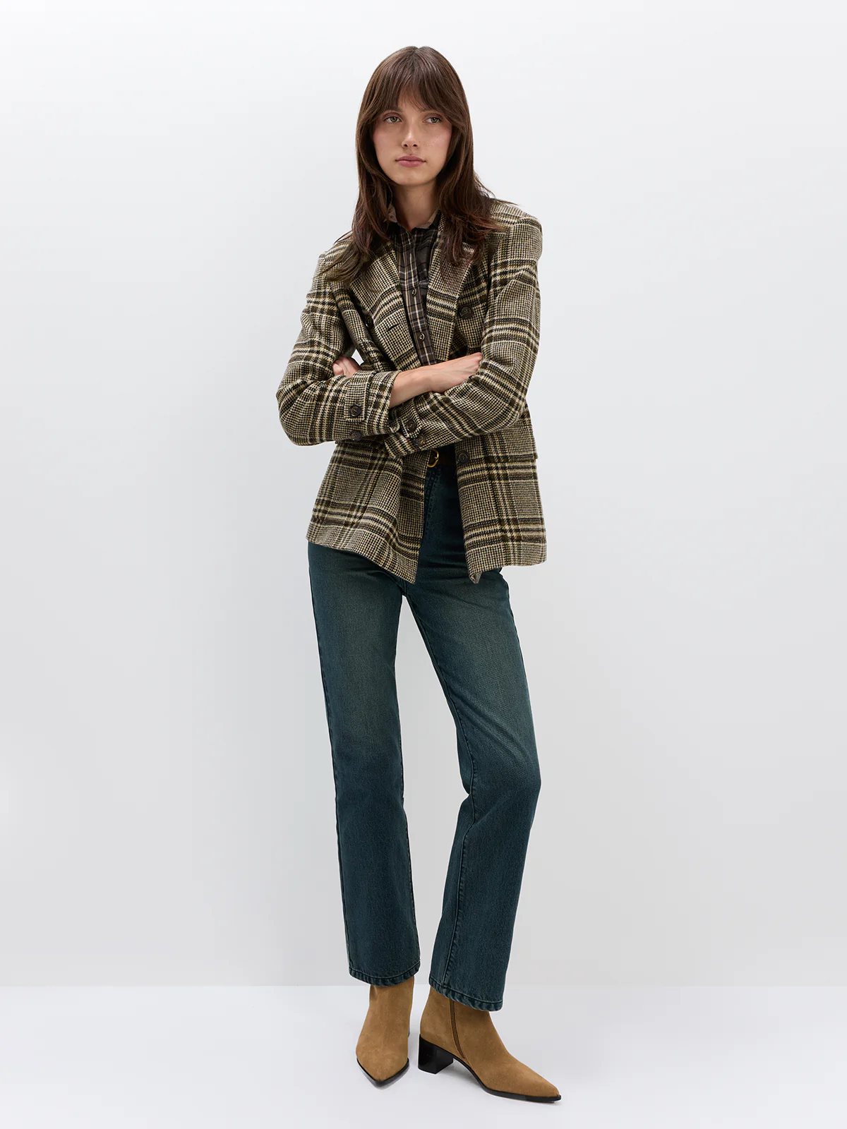 Front view of model in Blue mid-rise slim straight jeans paired with a knit top and flats.