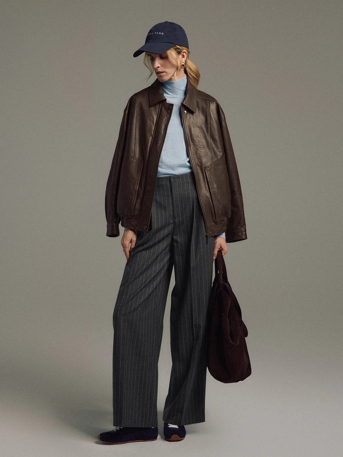 Model wearing a Dark Brown Italian shearling leather jacket, front-three-quarter view, hands in pockets.