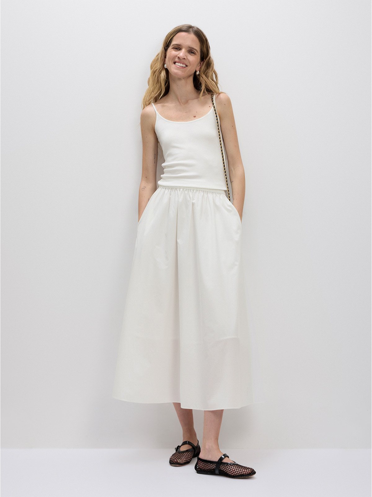 Ivory Lyocell cotton A-line maxi skirt with white tank top and black mesh Mary Janes, full-body studio shot