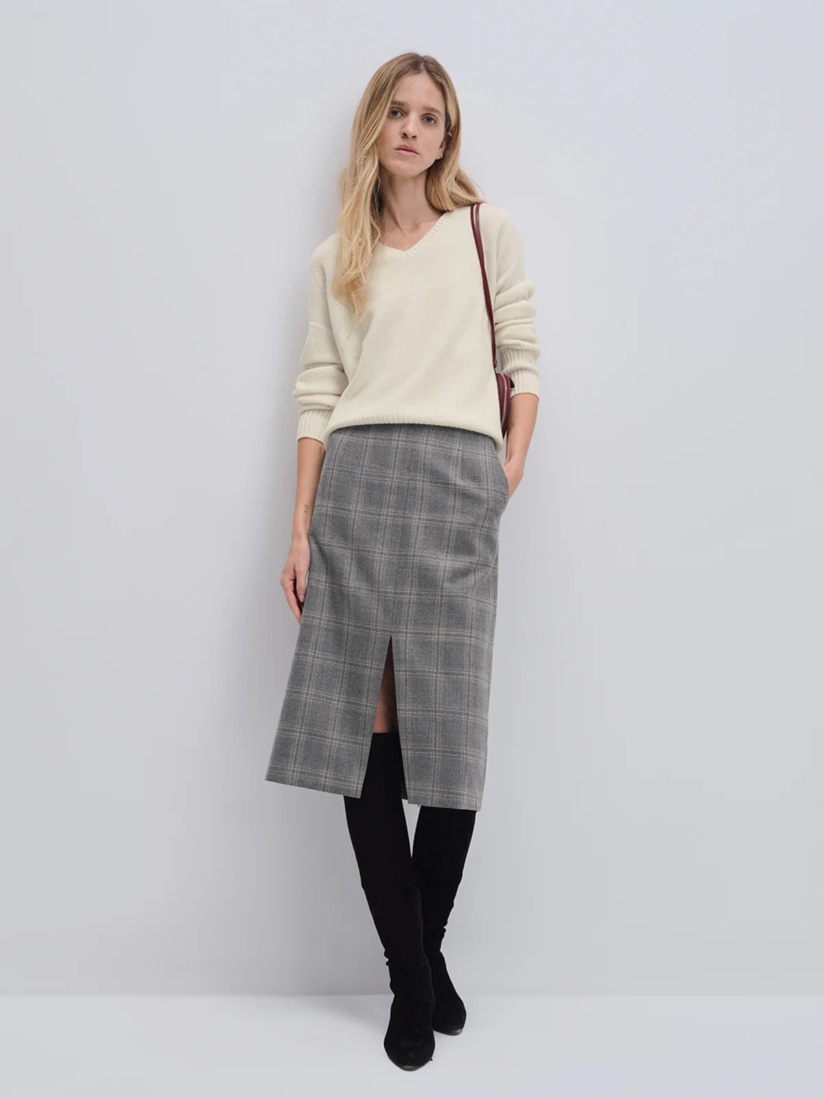 Model wearing andreatang pure wool blue-grey check midi skirt with front vent, styled with ivory knit and black boots