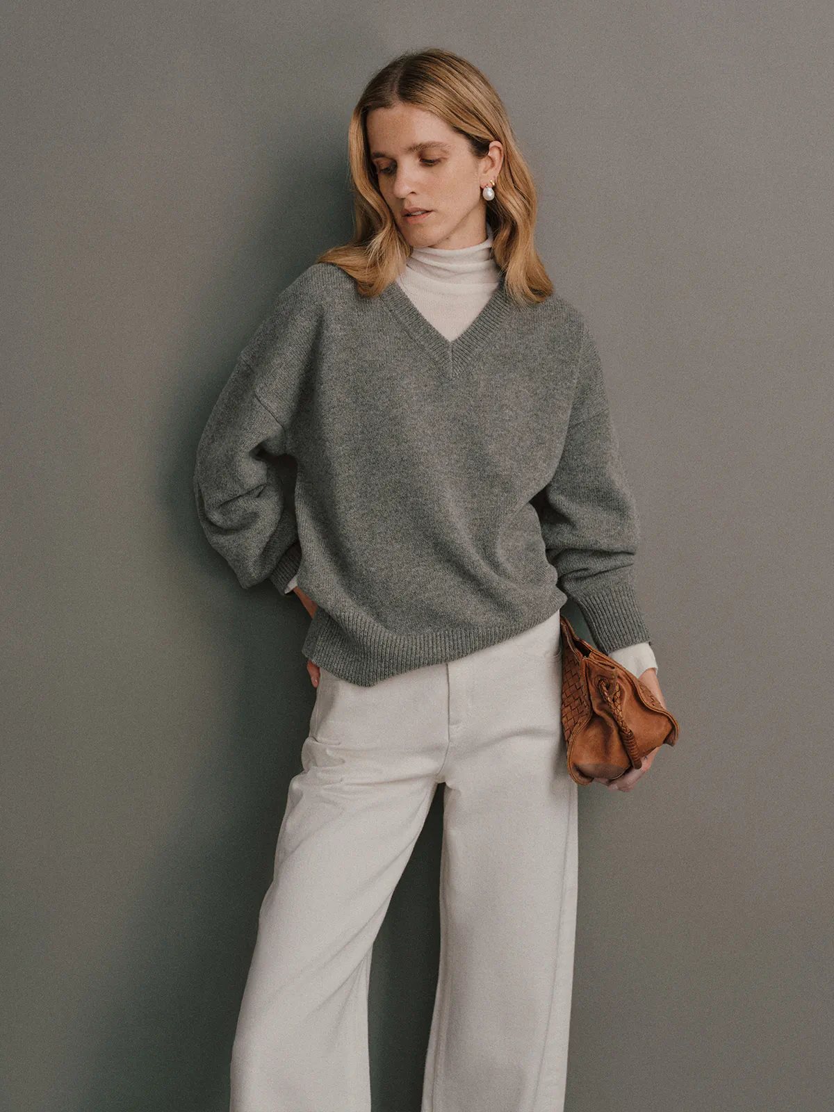 Close-up side view of the Black CARRIE Merino Wool V-Neck Jumper showing a small embroidered logo on the cuff.