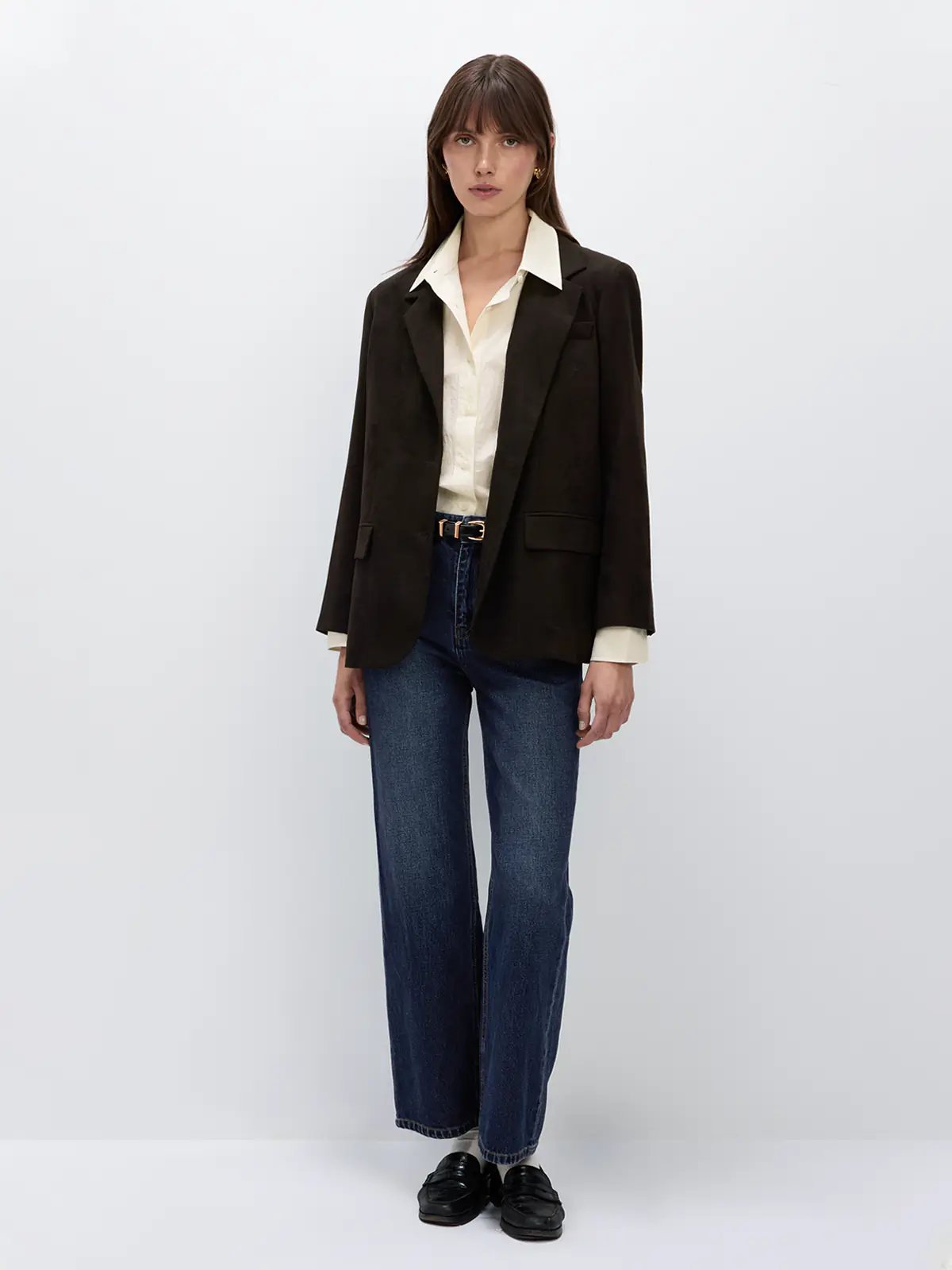 Beige NAOMI shirt worn untucked under a dark blazer, paired with jeans and shoes.