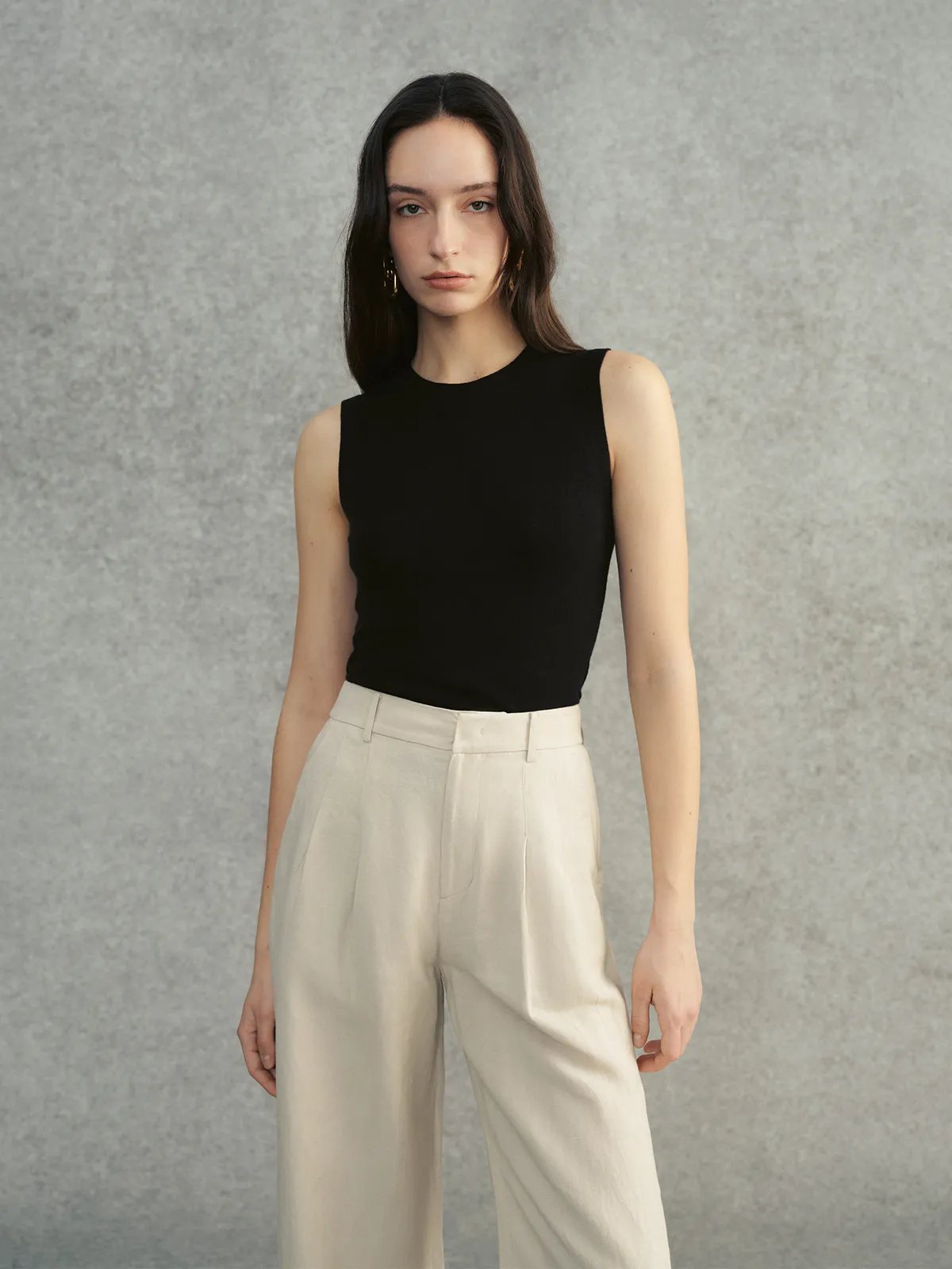 Model in black DELIA knit top with ivory wide-leg trousers, front-facing pose against neutral backdrop