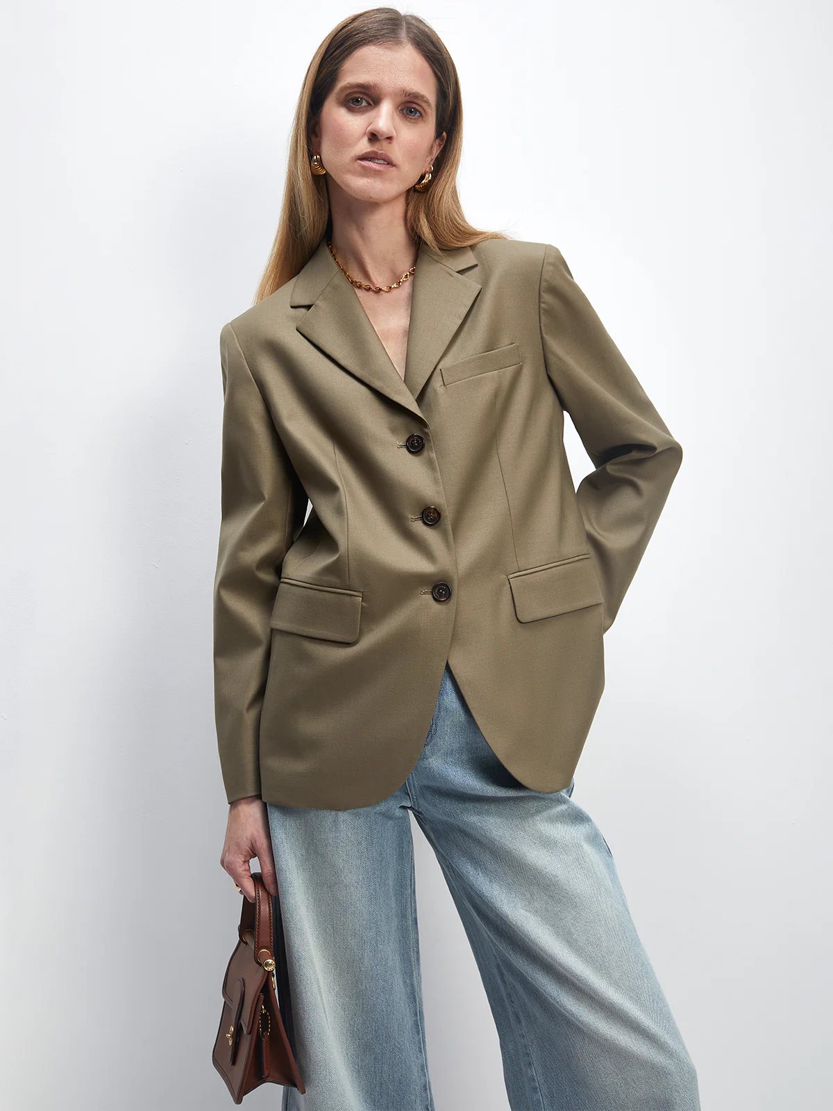 Front view of the Khaki Green Wool Acetate Cuban-Collar Blazer layered over a striped top and trousers.