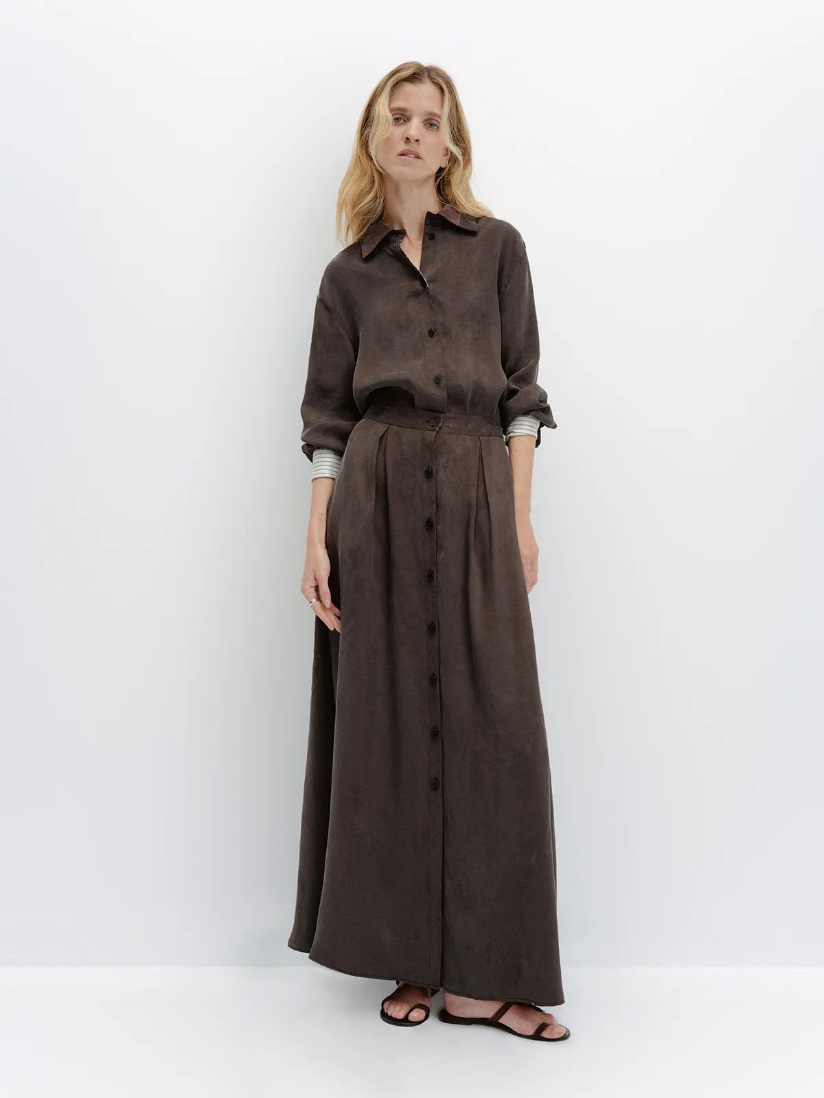 Front view of model in brown NOBU Maxi Skirt with matching shirt, neutral expression