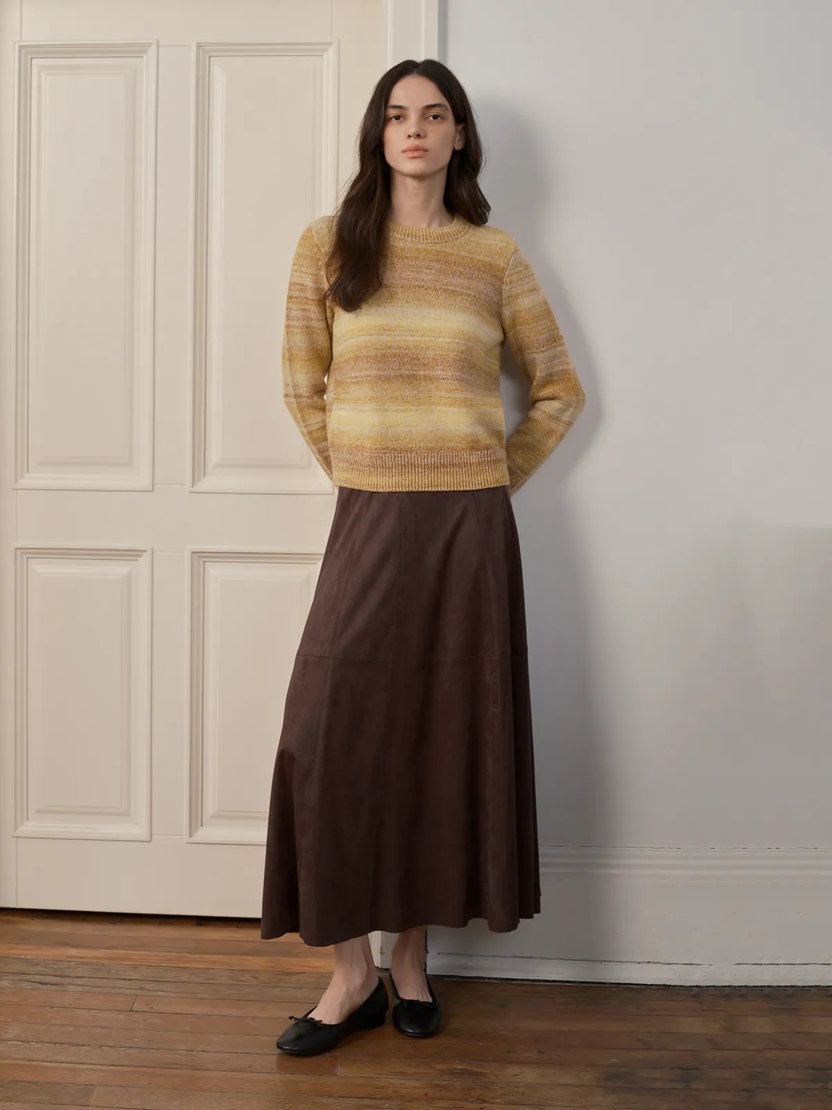 Model in TANYA Gradient Stripe Knit Vest with brown leather midi skirt and black ballet flats