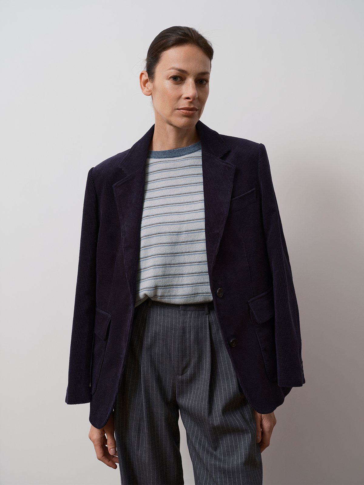 KIMBERLEY relaxed corduroy blazer in deep navy worn over striped knit and pinstripe trousers