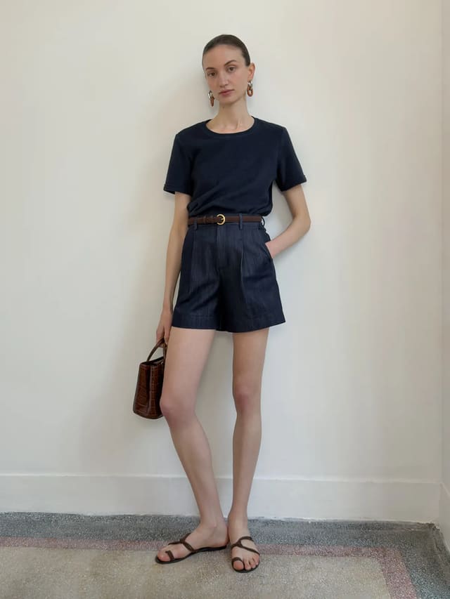 Model wearing RANGER suede leather belt with navy cotton tee and high-waisted denim shorts, minimalist styling against white wall