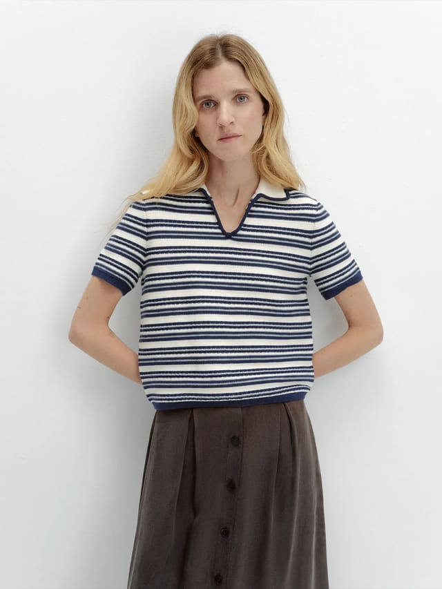 Front pose of model in ANGELINA striped polo with hands on hips, brown midi skirt