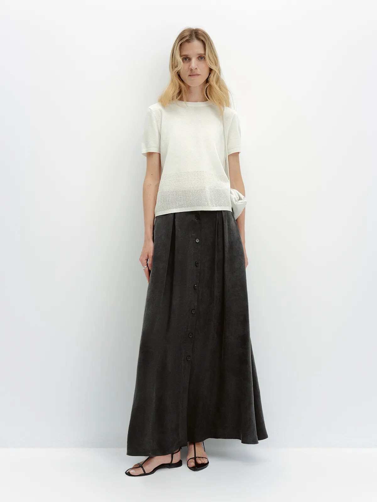 LIANA knit t-shirt styled with black button-front maxi skirt and white clutch, full-length front pose