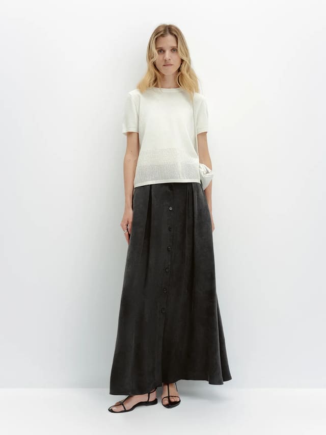 LIANA knit t-shirt styled with black button-front maxi skirt and white clutch, full-length front pose