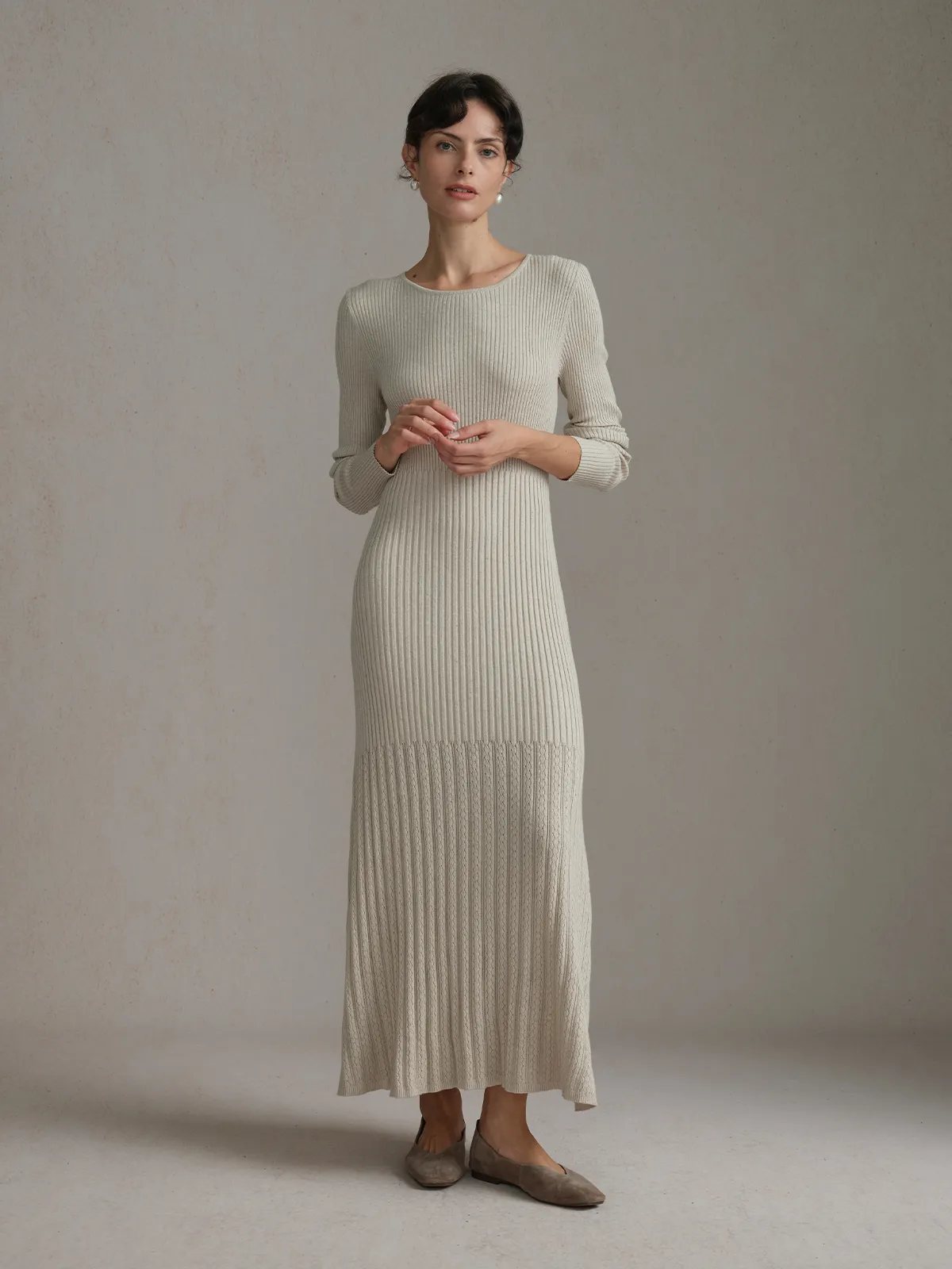 Front full-body view of model in oatmeal BRENDA dress with hands clasped, neutral background