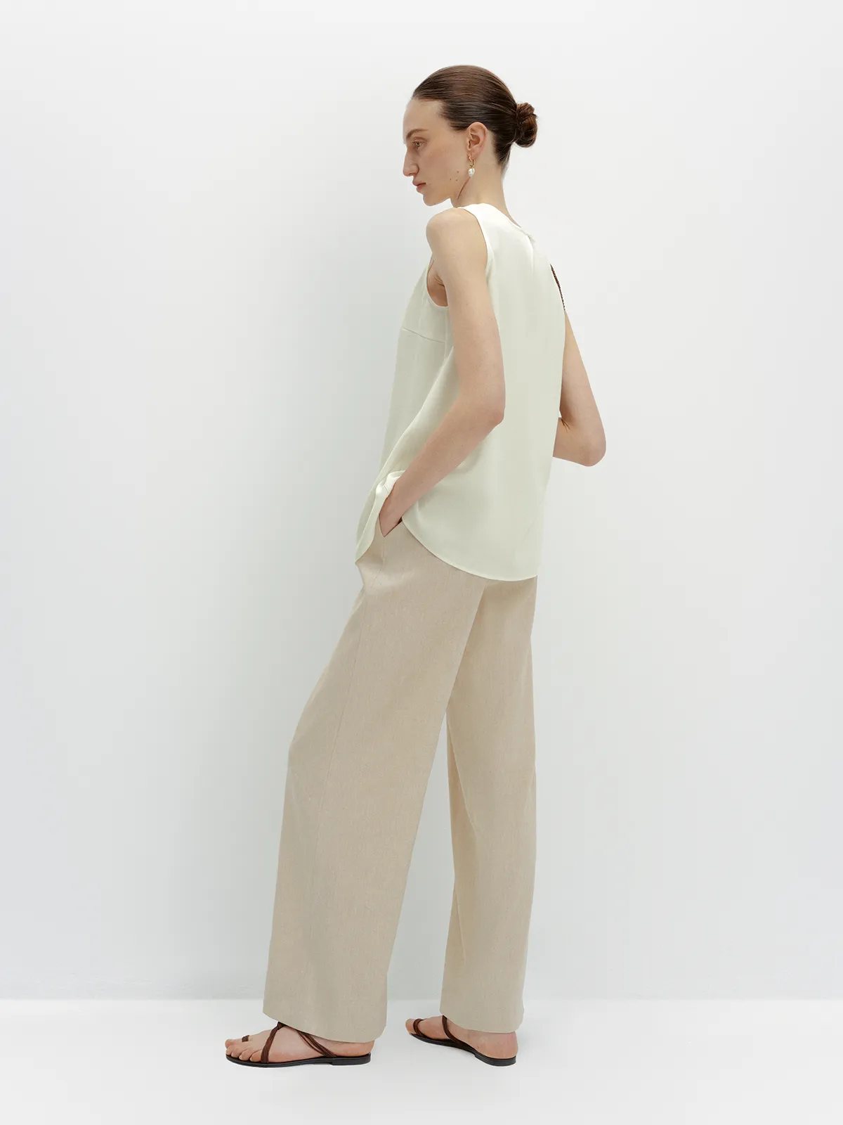 Back view of FINN linen trousers with ivory top and hand in pocket