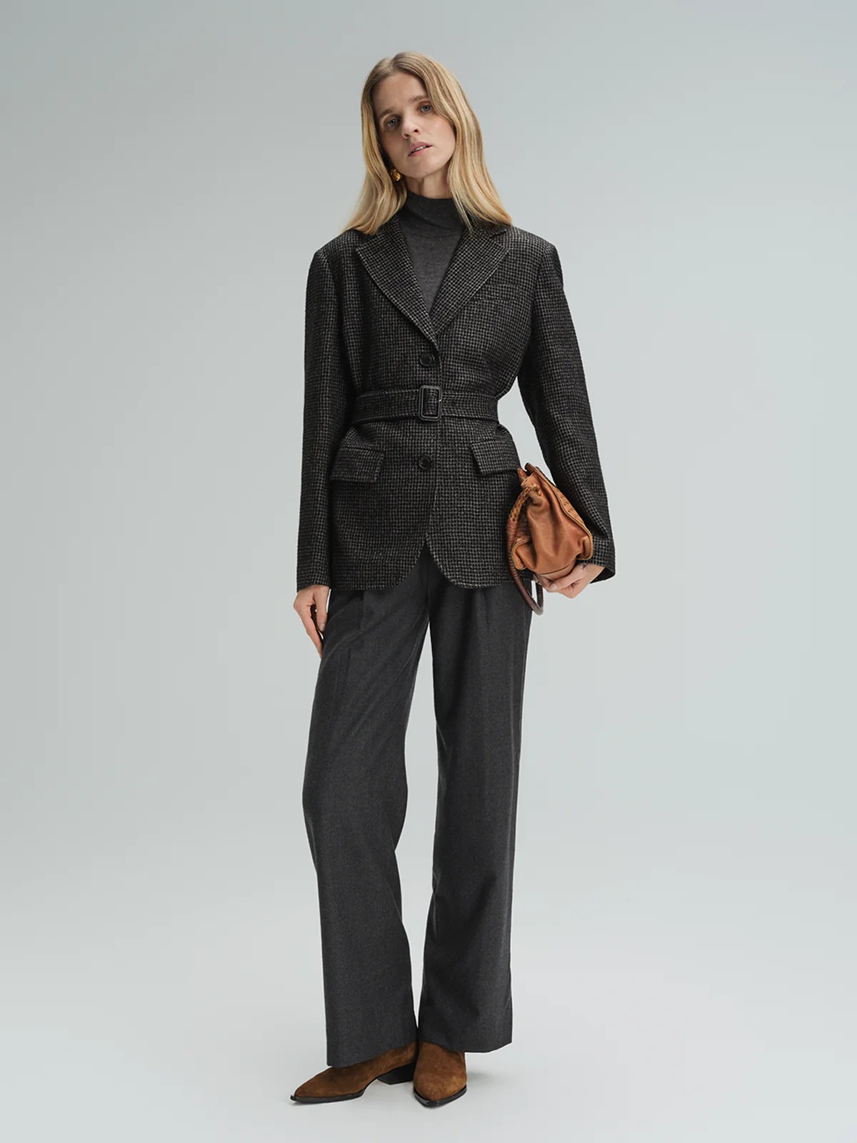 Model wearing andreatang black and grey houndstooth wool-blend belted blazer with wide-leg trousers