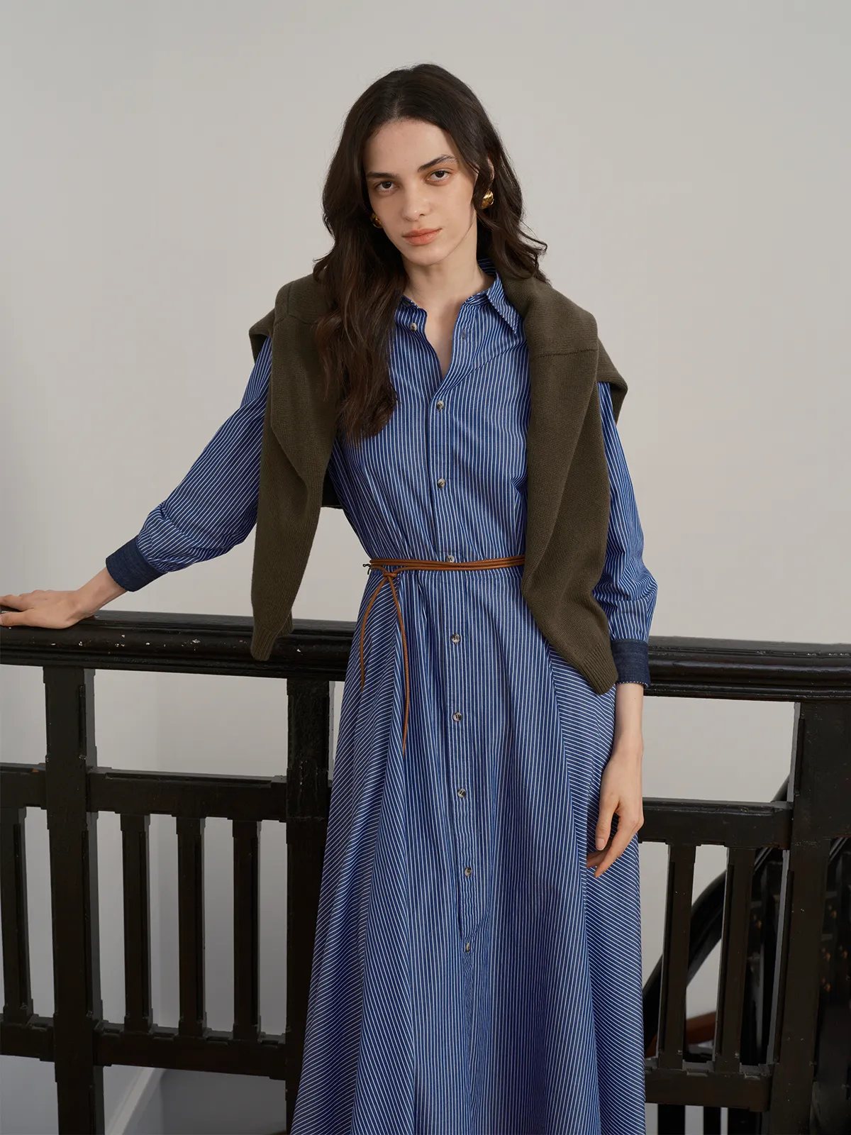 Andreatang BLUE SAIL Midi dress layered with olive green knit vest, tan leather belt, on model leaning against railing