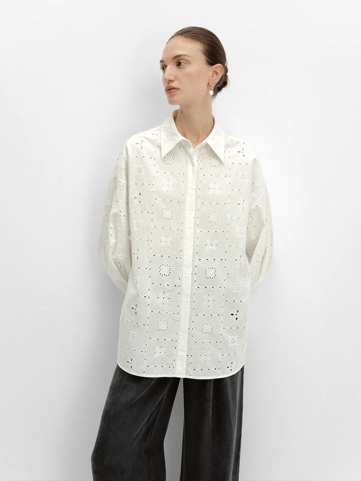 Side profile of MINA white eyelet shirt with black velvet trousers, minimalist fashion editorial