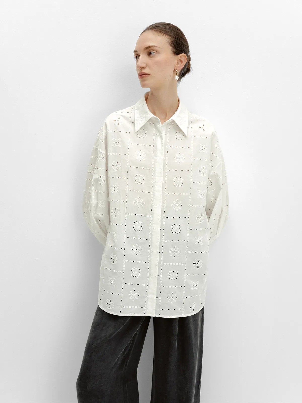 Side profile of MINA white eyelet shirt with black velvet trousers, minimalist fashion editorial