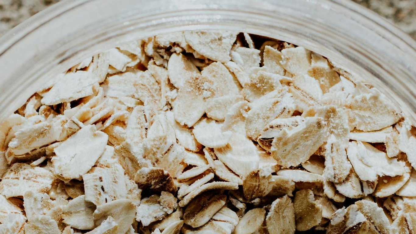 Close-up of rolled oat flakes in a glass container.